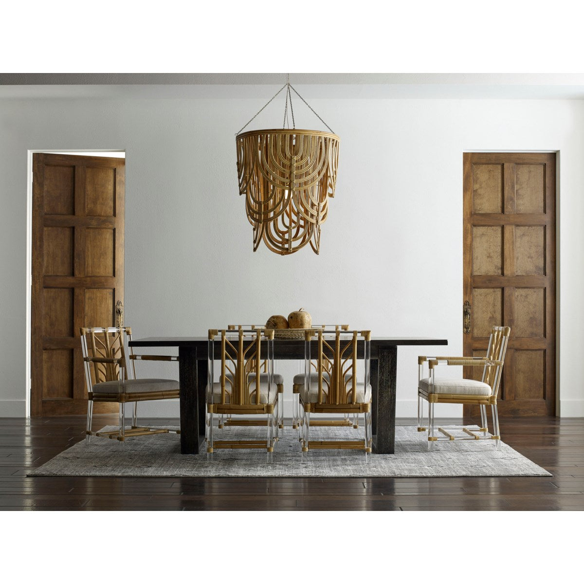 Modern dining room with a large wooden table, eclectic chandelier, and Selamat Acrylic and Rattan Side Chairs.