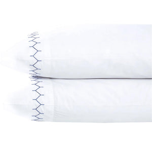 Two John Robshaw Stitched Pillowcase Pairs in Indigo, made from soft long-staple cotton with blue embroidered seams on one end, are stacked against a plain white background.
