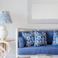 A blue and white couch with a Michelena Chalk White Gourd Lamp featuring a linen shade on a table.