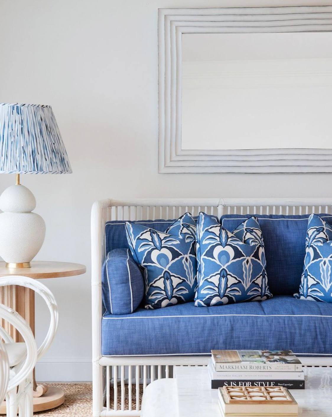 A blue and white couch with a Michelena Chalk White Gourd Lamp featuring a linen shade on a table.