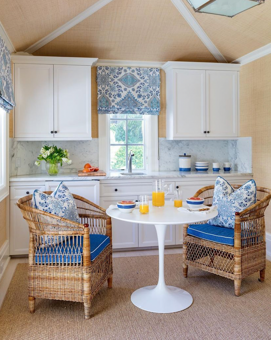 Two PALECEK hand-woven rattan chairs and a table in a kitchen.
