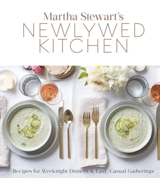 Cover of "Martha Stewart's Newlywed Kitchen" by Penguin Random House showcases a contemporary couple's cookbook, accompanied by a table setting with two bowls of soup, cutlery, wine glasses, and a floral centerpiece—ideal for entertaining friends or preparing quick weeknight dinners.